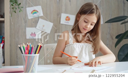Creative child drawing at the desk at home or school class room 122955204