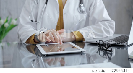 Doctor woman using tablet on the glass desk in medical office. Medicine and health care 122955312
