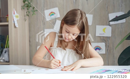 Creative child drawing at the desk at home or school class room Creative child drawing at the desk at home or school class room 122955320
