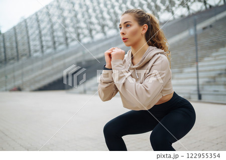 Active lifestyle. Young fitness woman exercising and stretching outdoors. Sports, sports training. Active lifestyle. Young fitness woman exercising and stretching outdoors. Sports, sports training. 122955354