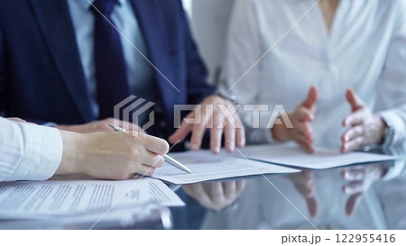 Diverse business people discussing contract papers before signing. Teamwork of lawyers Diverse business people discussing contract papers before signing. Teamwork of lawyers 122955416