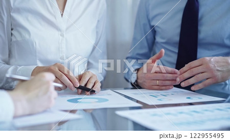 Business people are reviewing a financial results and discussing the terms of the agreement. Teamwork and planning 122955495