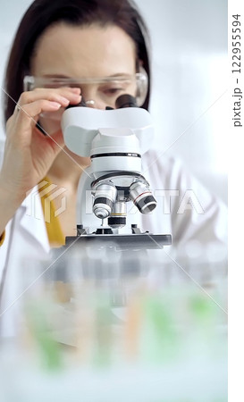 Woman scientist using microscope in laboratory. Microbiology science concept Woman scientist using microscope in laboratory. Microbiology science concept 122955594