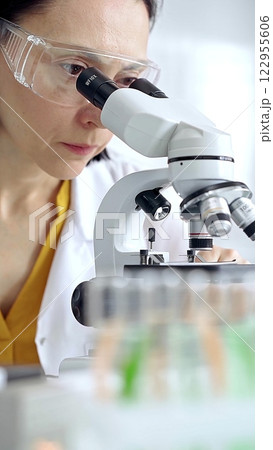 Woman scientist using microscope in laboratory. Microbiology science concept 122955606