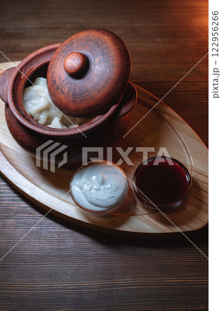 Hot, juicy dumplings snuggled in a pot. Next to it 122956266