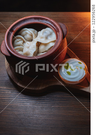 Hot, juicy dumplings snuggled in a pot. Next to it Hot, juicy dumplings snuggled in a pot. Next to it 122956268