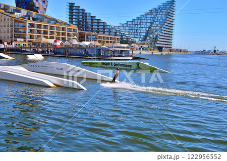 Man wakeboarding in front of modern residential neighborhood at Aarhus in Denmark Man wakeboarding in front of modern residential neighborhood at Aarhus in Denmark 122956552