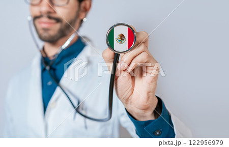 Doctor holding stethoscope with Mexico flag. Mexico Health and Care Concept, Mexico flag on stethoscope 122956979