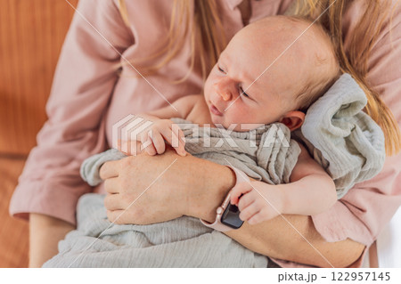 A mother lovingly embraces her newborn baby, holding them close to her chest. A tender moment of warmth, security, and deep maternal love, symbolizing bonding, comfort, and the unbreakable connection 122957145