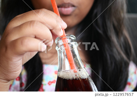 Enjoying a Refreshing Beverage Served in a Glass Bottle with a Straw 122957657