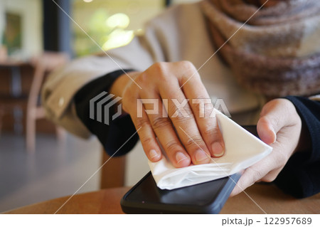 Cleaning a smartphone while enjoying a cafe moment 122957689