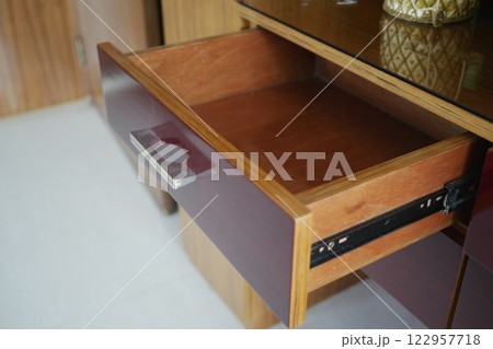 Open drawer in wooden cabinet revealing its interior space 122957718