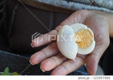 Perfectly boiled egg held in hand near fresh ingredients Perfectly boiled egg held in hand near fresh ingredients 122957800