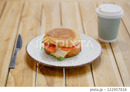 Fresh sandwich and beverage on wooden table at cozy cafe 122957816
