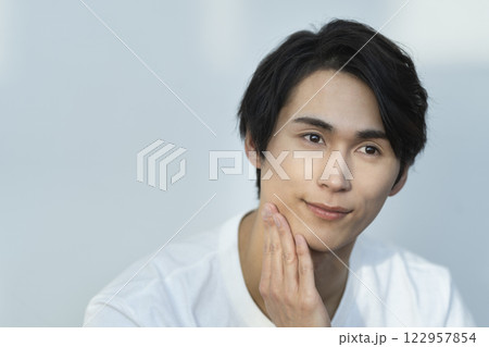 メンズビューティ　スキンケア　イメージ　顔に手をあてる若い男性 122957854