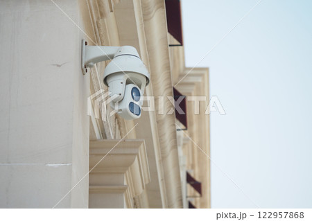 Security camera mounted on a building during daylight in an urban area 122957868