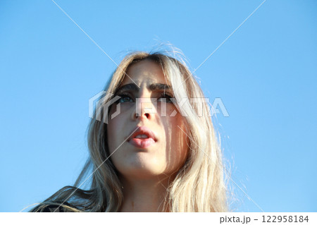 Worried Woman Standing Under Blue Sky Worried Woman Standing Under Blue Sky 122958184