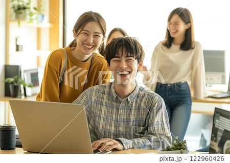 若い日本人たちが輝くオフィスで笑顔で協力し合う風景 122960426