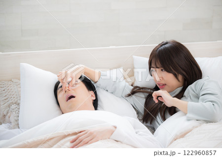 夫やパートナーのイビキがうるさくて眠れなかった女性　鼻をつまむ 122960857