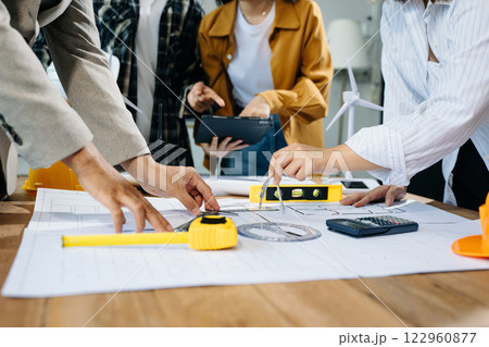 Engineer desk with object paper and tablet with blurry engineer teamwork hardworking Engineer desk with object paper and tablet with blurry engineer teamwork hardworking 122960877