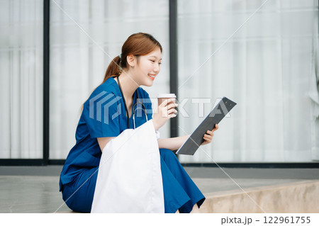 Asian woman part time doctorRepresentation of the daily life of a nurse going to work. Young, confident nurse outside looking away with smile on her face. Asian woman part time doctorRepresentation of the daily life of a nurse going to work. Young, confident nurse outside looking away with smile on her face. 122961755