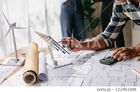 Engineer Teamwork Meeting, Drawing working on blueprint meeting for project working with partner on model building at company office. Engineer Teamwork Meeting, Drawing working on blueprint meeting for project working with partner on model building at company office. 122961886
