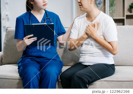Asian caregiver doctor examine older patient use blood pressure gauge. woman therapist nurse at nursing home taking care of senior elderly 122962166