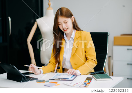 Asian tailor woman working on clothes in tailoring atelier. beautiful young female fashion designer smile 122962333