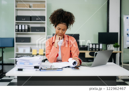 Young businesswoman working with working notepad, tablet and laptop documents talking on the smartphone, tablet Young businesswoman working with working notepad, tablet and laptop documents talking on the smartphone, tablet 122962467