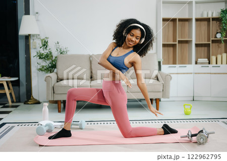 A young woman practices yoga and stretching with a mat and gym props, showcasing wellness, motivation, A young woman practices yoga and stretching with a mat and gym props, showcasing wellness, motivation, 122962795