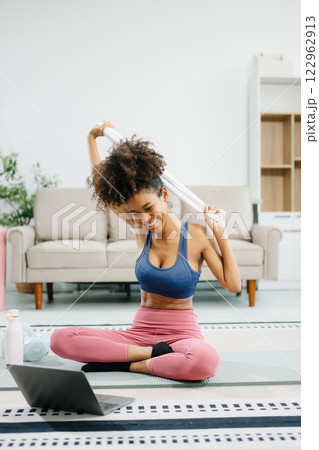 A young woman practices yoga and stretching with a mat and gym props, showcasing wellness, motivation, A young woman practices yoga and stretching with a mat and gym props, showcasing wellness, motivation, 122962913