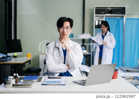 Doctor analyzing patient data on tablet in clinical lab. Medical professional in hospital with laptop, blood samples 122962997