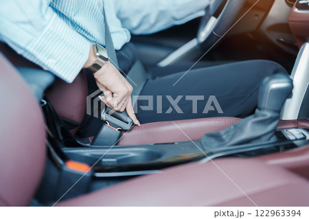 Business woman driver hand fastening seat belt during sitting inside a car and driving in the road. safety, trip, journey and transport concept 122963394