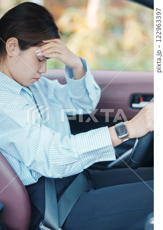 woman feeling stress and angry during drive car long time. Asian girl tired and fatigue having headache after driving car in traffic jam. Sleepy, stretching and drunk concept 122963397