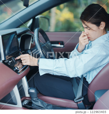 Asian woman hold nose because bad smell after turn on air conditioning in car. Woman driving car with broken air conditioning in hot summer weather. Businesswoman driver is tired, overheat and stress Asian woman hold nose because bad smell after turn on air conditioning in car. Woman driving car with broken air conditioning in hot summer weather. Businesswoman driver is tired, overheat and stress 122963403