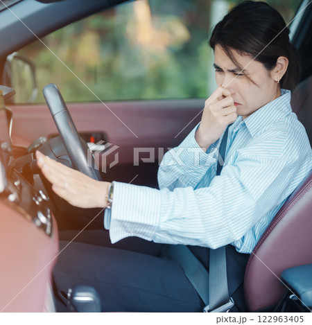 Asian woman hold nose because bad smell after turn on air conditioning in car. Woman driving car with broken air conditioning in hot summer weather. Businesswoman driver is tired, overheat and stress Asian woman hold nose because bad smell after turn on air conditioning in car. Woman driving car with broken air conditioning in hot summer weather. Businesswoman driver is tired, overheat and stress 122963405