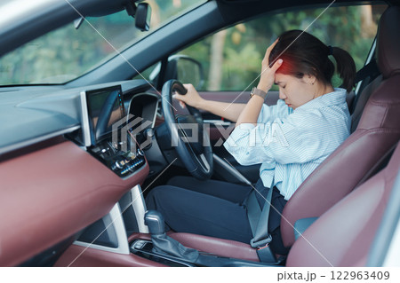 woman feeling stress and angry during drive car long time. Asian girl tired and fatigue having headache after driving car in traffic jam. Sleepy, stretching and drunk concept woman feeling stress and angry during drive car long time. Asian girl tired and fatigue having headache after driving car in traffic jam. Sleepy, stretching and drunk concept 122963409
