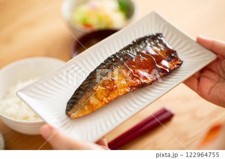 和食の朝食で鯖の照り焼きを食べるミドル女性 122964755