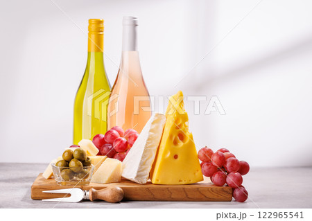 A delectable arrangement of various cheeses, fresh grapes, and wine 122965541