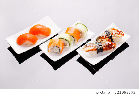 Assorted sushi and maki rolls beautifully arranged on plates Assorted sushi and maki rolls beautifully arranged on plates 122965573