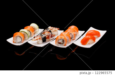 Assorted sushi and maki rolls beautifully arranged on plates Assorted sushi and maki rolls beautifully arranged on plates 122965575