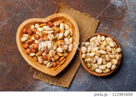 A vibrant mix of various nuts, including almonds, walnuts, hazelnuts, cashews, and pistachios 122965889