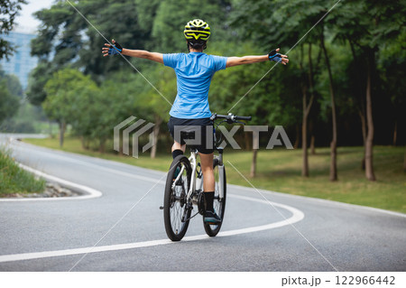 Riding bike with hands free in park 122966442