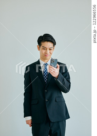 スマホを持つ20代の若い男性 122966556