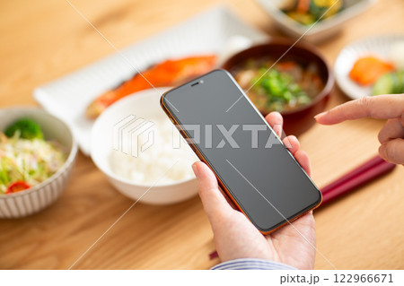 和食の朝ごはんとスマホを持つミドル女性の手 和食の朝ごはんとスマホを持つミドル女性の手 122966671