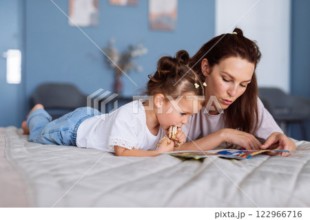 Mother and daughter read a story together 122966716