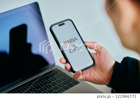 スマホを操作する20代の若い男性　新NISA&iDeCo 122966771