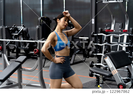 young woman is standing and resting on Wipe the sweat  an exercise machine 122967862