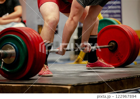 strong athlete focuses on lifting heavy barbell during deadlift competition strong athlete focuses on lifting heavy barbell during deadlift competition 122967894