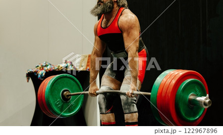 strong athlete lifts heavy barbell during powerlifting competition held in local gym strong athlete lifts heavy barbell during powerlifting competition held in local gym 122967896
